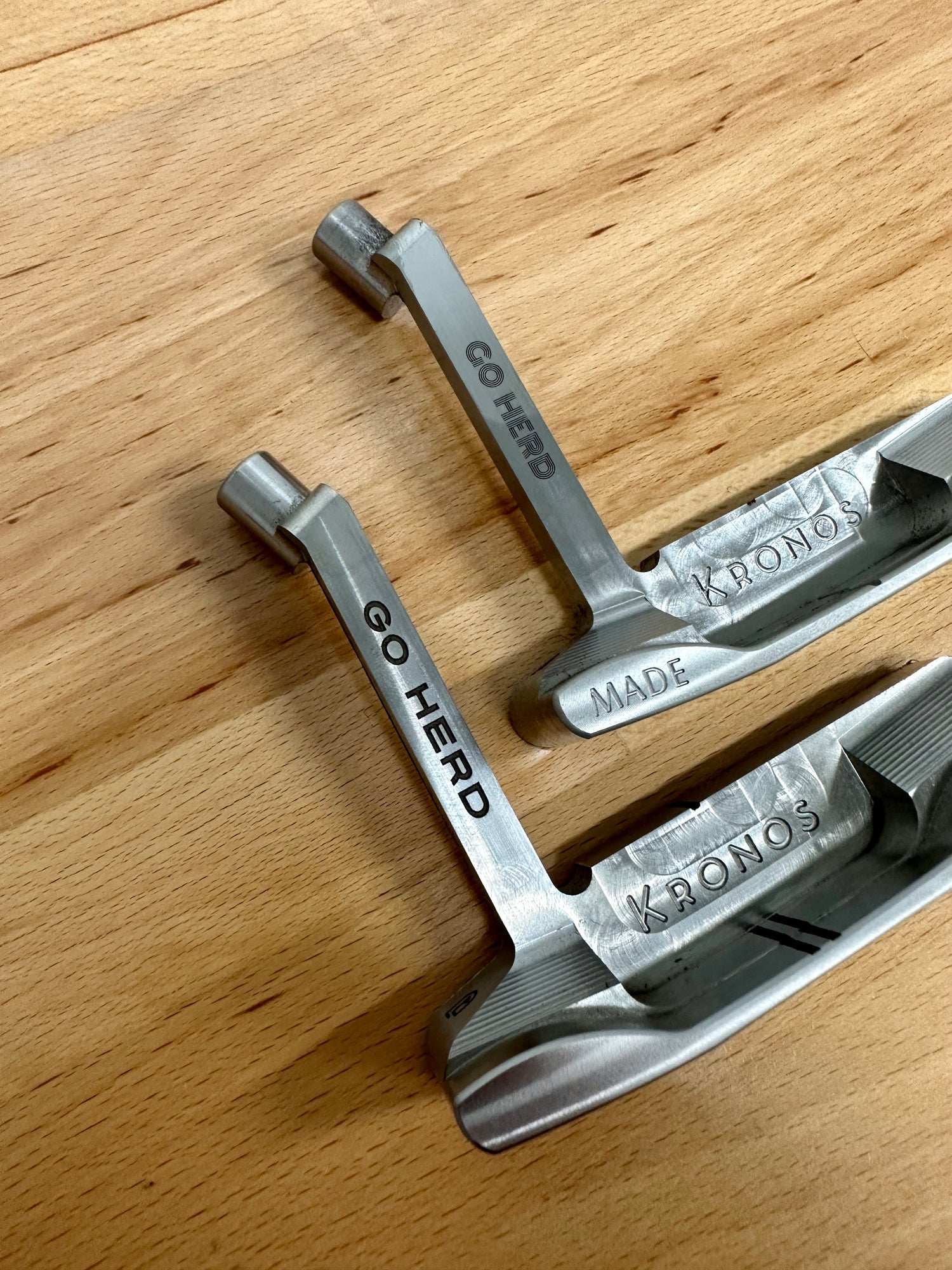 two Release Model putters with words Go Herd engraved on the neck